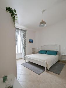 a white bedroom with a bed and a window at Al Porticciolo di Savelletri in Savelletri di Fasano