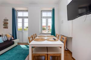 uma sala de estar com uma mesa e cadeiras e um sofá em Stay in Todi - Alojamento Local em Setúbal
