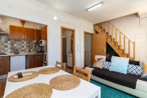 uma sala de estar com duas mesas e um sofá em Stay in Todi - Alojamento Local em Setúbal