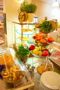 un buffet con tazones de frutas y hortalizas en un mostrador en eco Hotel Milano & BioRiso Restaurant, en Milán