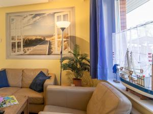 una sala de estar con sofá y una foto de un muelle en Apartment Kiebitzweg-2 by Interhome, en Sehestedt