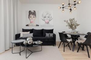 Fashionable City Center Apartment by Renters في وارسو: غرفة معيشة مع أريكة سوداء وطاولة