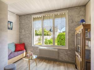 a living room with a couch and a window at Holiday Home Ty Martelod - SGU108 by Interhome in Saint-Guénolé