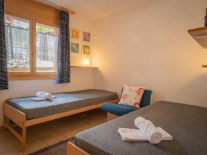 a room with two beds and a chair and a window at Apartment La Rèze No 6 by Interhome in Ovronnaz