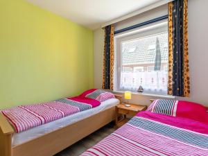 2 camas en una habitación con ventana en Apartment Kiebitzweg-1 by Interhome en Sehestedt