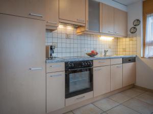 een keuken met witte kasten en een fornuis met oven bij Apartment La Rèze No 6 by Interhome in Ovronnaz