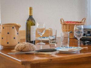 a wooden table with a bottle of wine and glasses at Apartment La Rèze No 6 by Interhome in Ovronnaz