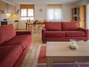 een woonkamer met twee rode banken en een tafel bij Apartment Rèze 6 by Interhome in Ovronnaz