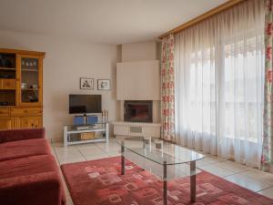 uma sala de estar com uma mesa de vidro e uma televisão em Apartment La Réze No 5 by Interhome em Ovronnaz