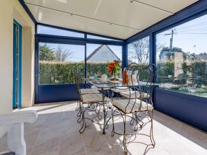 a porch with a table and chairs and windows at Holiday Home Colibri by Interhome in Saint-Germain-sur-Ay +12 photos