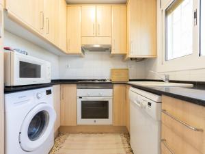 a kitchen with a washing machine and a microwave at Apartment Mas Baixuli by Interhome in Tarragona