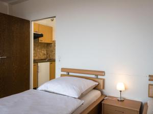 ラーンシュタインにあるApartment B715 by Interhomeの小さなベッドルーム(ベッド1台、ランプ付きのナイトスタンド付)