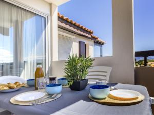 a table with a blue table cloth and food on it at Apartment Les Capitelles by Interhome in Saint-Cyprien-Plage