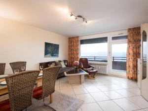 a living room with a couch and a table and chairs at Apartment B1101 by Interhome in Lahnstein
