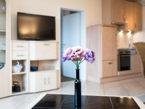 un jarrón con flores púrpuras sentado sobre una mesa en Apartment B1101 by Interhome, en Lahnstein