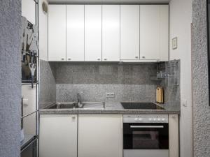 ラーンシュタインにあるApartment A805 by Interhomeの白いキャビネットとシンク付きのキッチン