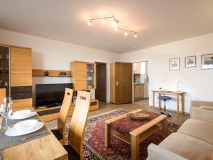 ein Wohnzimmer mit einem Tisch, einem Sofa und einem TV in der Unterkunft Apartment B901 by Interhome in Lahnstein