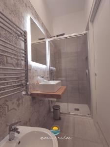 y baño con lavabo y ducha con espejo. en Mare & Relax en Margherita di Savoia