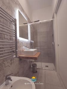 Un baño con lavabo y ducha con espejo. en Mare & Relax delux, en Margherita di Savoia 16 fotos más