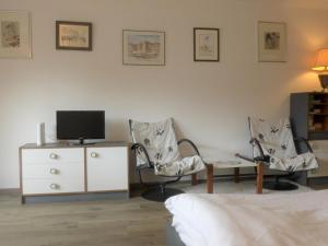 1 dormitorio con 2 sillas, TV y tocador en Studio Silence-4 by Interhome, en Zermatt