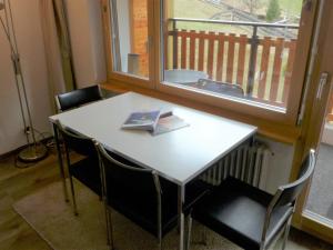 una mesa blanca con sillas y un libro sobre ella en Studio Silence-4 by Interhome, en Zermatt