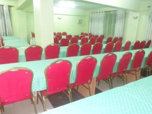 a conference room with red chairs and a white table at Grenville Hotel in Oyugis