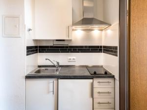 a kitchen with white cabinets and a sink at Apartment Pusteblume - B609 by Interhome in Lahnstein
