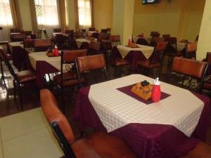 a dining room with tables and chairs and tablesktop at Grenville Hotel in Oyugis