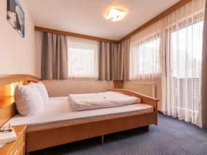 ein Schlafzimmer mit einem Bett in einem Zimmer mit Fenstern in der Unterkunft Apartment Apart Romantica - KPL211 by Interhome in Kappl
