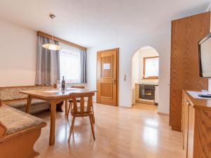 kuchnia i salon ze stołem i krzesłami w obiekcie Apartment Apart Romantica-3 by Interhome w mieście Kappl