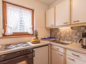 kuchnia ze zlewem, kuchenką i oknem w obiekcie Apartment Apart Romantica-3 by Interhome w mieście Kappl