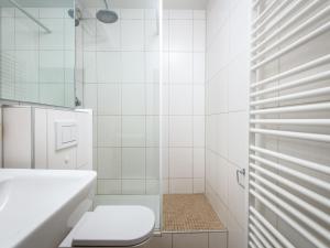 La salle de bains blanche est pourvue d'une douche et de toilettes. dans l'établissement Apartment B1013 by Interhome, à Lahnstein