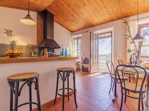 eine Küche mit Holzdecken und einer Theke mit Stühlen in der Unterkunft Holiday Home Le Prunier - ORN311 by Interhome in Oraison
