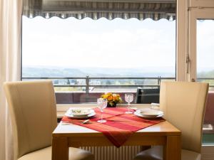 einem Esstisch mit 2 Stühlen und einem Tisch mit Weingläsern in der Unterkunft Apartment B615 by Interhome in Lahnstein
