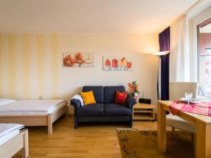 a bedroom with a bed and a blue couch in a room at Apartment B615 by Interhome in Lahnstein