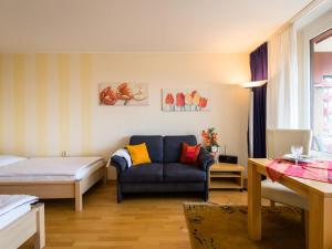 ein Schlafzimmer mit einem Bett und einem blauen Sofa in einem Zimmer in der Unterkunft Apartment B615 by Interhome in Lahnstein + 25 Fotos
