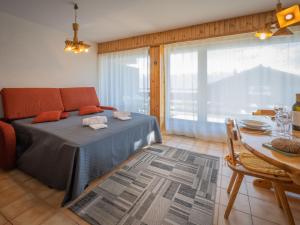 um quarto com uma cama, uma mesa e uma janela em Apartment Austral 204 by Interhome em Ovronnaz