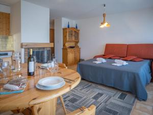 uma sala de estar com uma cama e uma mesa com uma garrafa de vinho em Apartment Austral 204 by Interhome em Ovronnaz