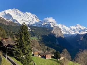 a village in the mountains with a snow covered mountain at Apartment Bluemewäg Apt-R by Interhome in Wengen