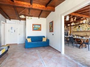 een woonkamer met een blauwe bank en een tafel bij Villa Albert by Interhome in San Leone