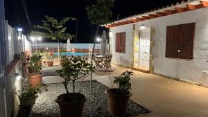 un patio con macetas y una piscina por la noche en CA LA LOLA, en Banyeres del Penedés