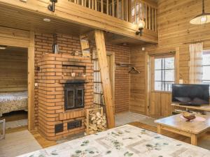 - un salon avec une cheminée dans une cabane en rondins dans l'établissement Holiday Home Suopursu by Interhome, à Pohjavaara