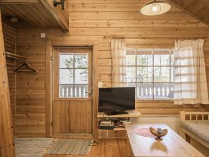 sala de estar con paredes de madera y TV de pantalla plana. en Holiday Home Suopursu by Interhome, en Pohjavaara