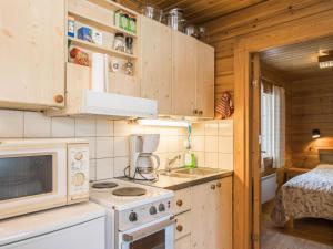 Il comprend une petite cuisine équipée d'un four micro-ondes et d'une cuisinière. dans l'établissement Holiday Home Suopursu by Interhome, à Pohjavaara