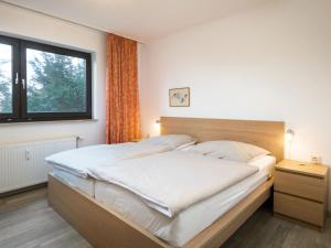 een slaapkamer met een groot bed en een raam bij Apartment A109 by Interhome in Lahnstein