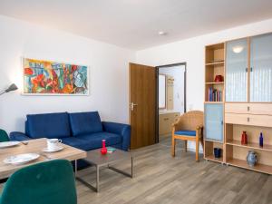 a living room with a blue couch and a table at Apartment A109 by Interhome in Lahnstein