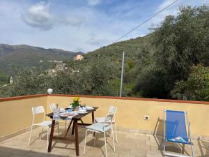 a table and chairs on a patio with mountains in the background at Apartment Adriana - PRE170 by Interhome in Valloria