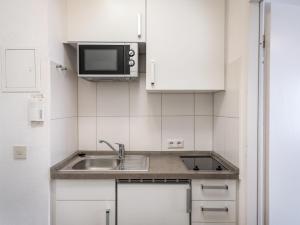 a small kitchen with a sink and a microwave at Apartment A706 by Interhome in Lahnstein