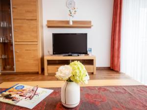 Un jarrón con flores en una sala de estar con televisión. en Apartment A706 by Interhome, en Lahnstein 26 fotos más