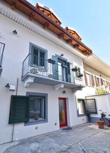 Casa blanca con balcón y puerta roja en iL GeLsoMiNo, en Brandizzo